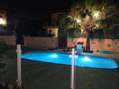 a swimming pool in a yard at night at Pousada Santa Genoveva campeche in Florianópolis