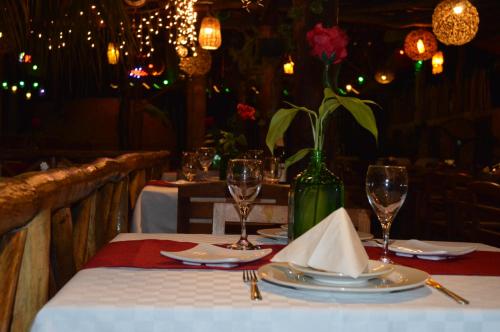 a table with plates and glasses and a vase with flowers at Hotel Casa San Juan in Valladolid