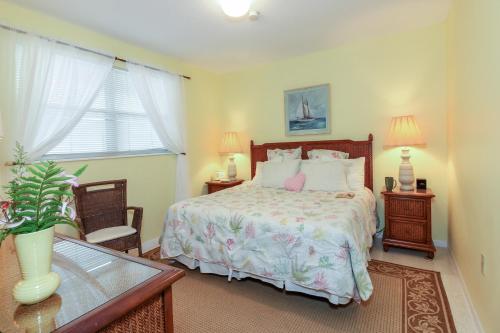 a bedroom with a bed and a table and two lamps at Bamboo Apartments in Holmes Beach
