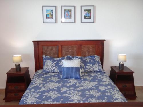 a bedroom with a blue bed with two night stands at Sunset Paradise - Ocean View Penthouse Apartment in Cabo Rojo