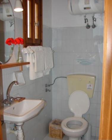 a small bathroom with a toilet and a sink at Harry's Studios 1 in Gaios