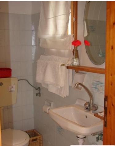 a bathroom with a sink and a toilet and a mirror at Harry's Studios 1 in Gaios