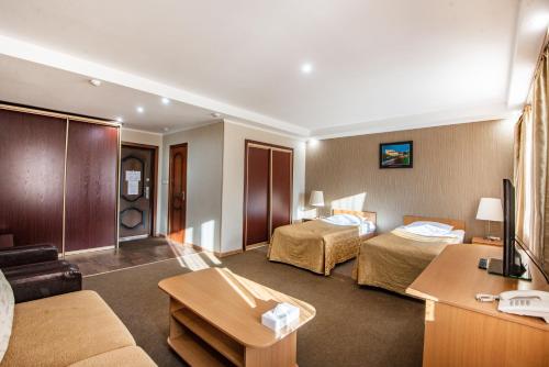 una habitación de hotel con dos camas y un sofá en Arirang Hotel, en Khabarovsk