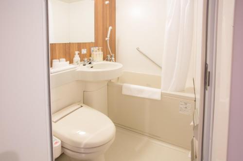 a white bathroom with a toilet and a sink at Kuretake-Inn Hamamatsueki Minamiguchi Premium in Hamamatsu