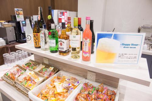a buffet filled with bottles of wine and food at Kuretake-Inn Hamamatsueki Minamiguchi Premium in Hamamatsu