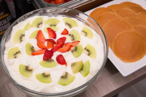 a bowl of yogurt with strawberries and kiwis on it at Kuretake-Inn Hamamatsueki Minamiguchi Premium in Hamamatsu
