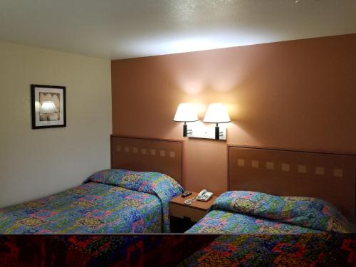 a hotel room with two beds and two lamps at America's Best Inn - Macon in Macon