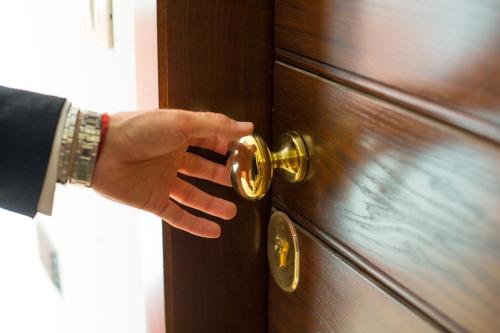 a hand is unlocking a door with a knob at Country Hotel & Resort I Calanchi in Ripatransone