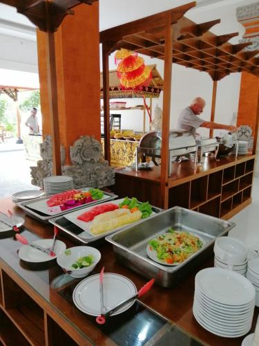 a buffet with several plates of food on a table at Swastika Bungalows in Sanur