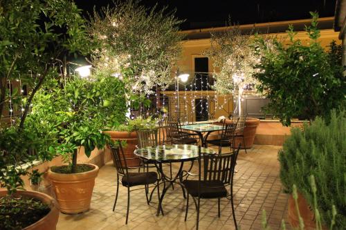 um pátio com mesas, cadeiras e vasos de plantas em Hotel dei Consoli Vaticano em Roma