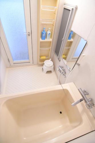 a bathroom with a sink and a mirror at Guest room Kamakura Nagomi -Camellia- in Kamakura