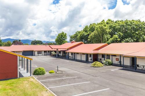 a row of buildings with a parking lot at ASURE Oak Estate Motor Lodge in Greytown