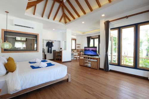 a bedroom with a white bed and a television at Lanta Casa Blanca in Ko Lanta