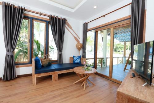 a living room with a couch and a tv at Lanta Casa Blanca in Ko Lanta