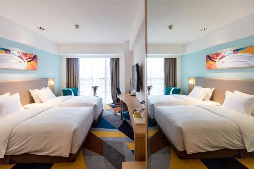 a hotel room with four beds and a desk at Holiday Inn Express Chengdu Xindu by IHG in Chengdu