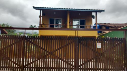 a yellow house with a fence in front of it at Camburi suites in Camburi