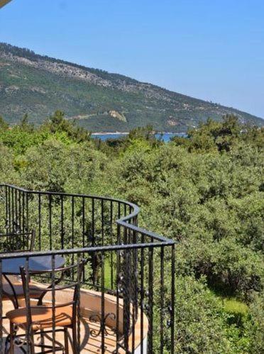a balcony with a table and chairs on a hill at King Studios in Kinira