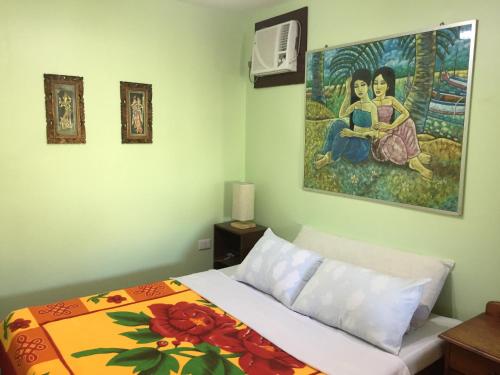 ein Schlafzimmer mit einem Bett und einem Wandgemälde in der Unterkunft Antonio's Pension House in Dipolog City