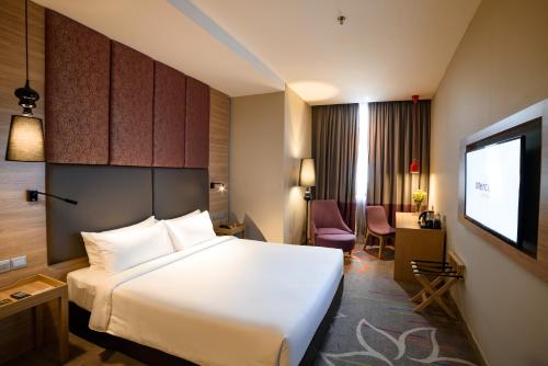 a hotel room with a bed and a flat screen tv at Mercure Selangor Selayang in Batu Caves