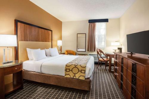 um quarto de hotel com uma cama e uma televisão de ecrã plano em Belmont Inn & Suites em Florida City