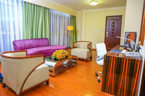 a living room with a purple couch and chairs at Denver boutique hotel in Addis Ababa
