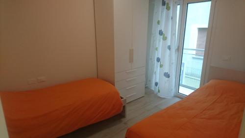 Un dormitorio pequeño con dos camas y una ventana. en casa olmo, en Caorle