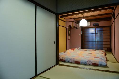 a bedroom with a bed in a room with a door at Nishioji TANUKI in Kyoto