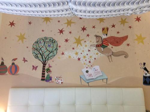 a wall with stars and a unicorn and a tree at Pupiang po Da Arte Resort in Dan Sai