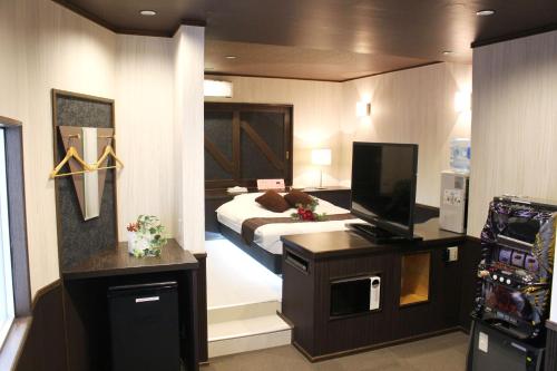 a bedroom with a bed and a television in it at Pal Annex Munakata (Love Hotel) in Munakata