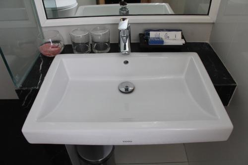 a white sink in a bathroom with a mirror at Hotel Namira Syariah Pekalongan in Pekalongan