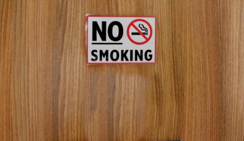 a no smoking sign on a wooden door at Hotel Namira Syariah Pekalongan in Pekalongan