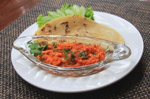 a glass bowl of food on a white plate at Hotel Namira Syariah Pekalongan in Pekalongan