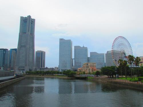 a river in front of a city with a roller coaster at ゲストハウス杉田 古民家貸切の完全プライベート空間 杉田駅徒歩2分 セルフチェックイン in Yokohama