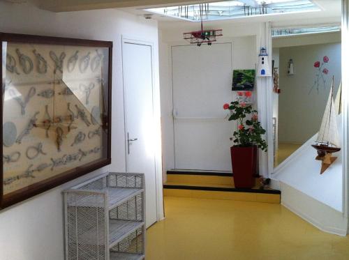 a hallway with a staircase and a painting on the wall at Hôtel Le Vivier WISSANT - Centre Village - Côte d'Opale - Baie de Wissant - 2CAPS in Wissant