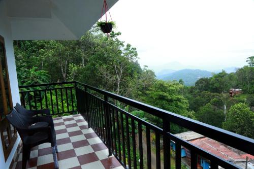 a balcony with a chair and a view of the mountains at Mountain Breeze Villa and Homestay in Idukki