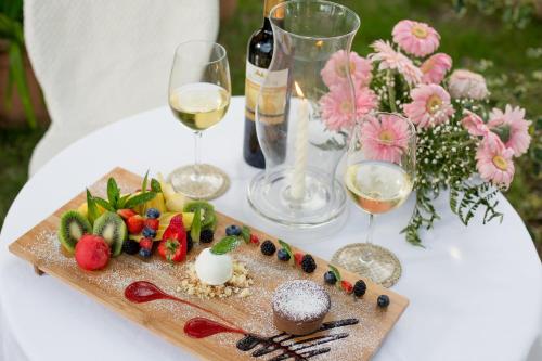 a table with a plate of food and glasses of wine at Country Hotel & Resort I Calanchi in Ripatransone