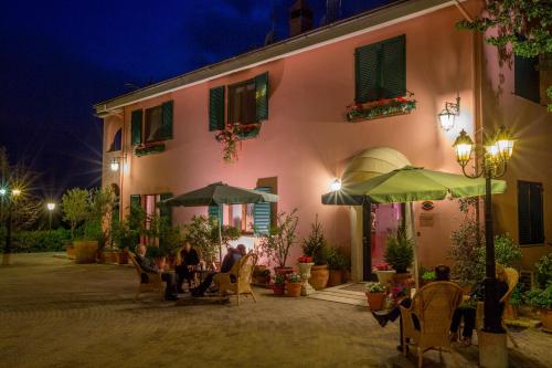 a group of people sitting outside of a building at night at Country Hotel & Resort I Calanchi in Ripatransone