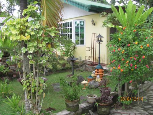 a garden with flowers and plants in front of a house at Villa 301 B&B in Baclayon