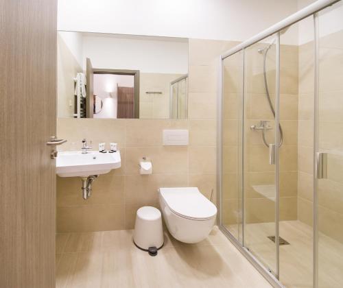 a bathroom with a toilet and a sink and a shower at Dangė Hotel in Klaipėda