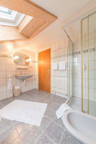 a bathroom with a tub and a sink at Pension Freiheit in Pfronten