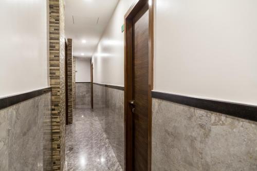 a hallway with a wooden door and a wall at City Guest House - Dadar in Mumbai