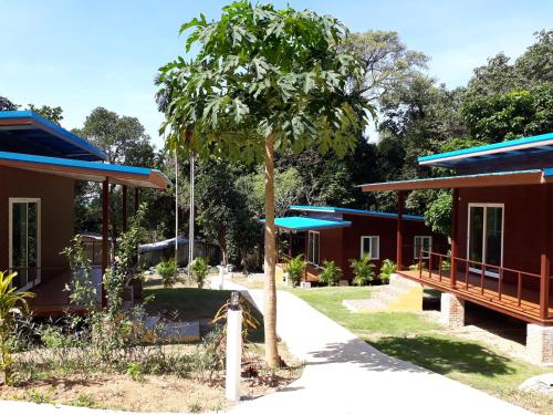 a row of cottages with a tree in the yard at Elephant & Castle in Ko Chang