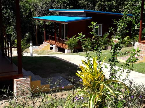 a garden with a house with a blue roof at Elephant & Castle in Ko Chang