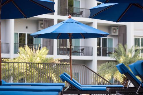 a group of blue lounge chairs and umbrellas at Koh Chang Paradise Hill in Ko Chang