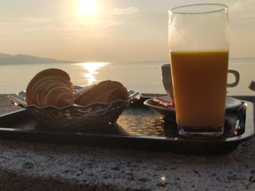 a plate of bread and a glass of beer on the beach at Hotel et Appartements Reine D'Azur in Roquebrune-Cap-Martin