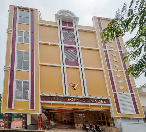 a large yellow building with people in front of it at Hotel Ramraj Regency in Nāgercoil