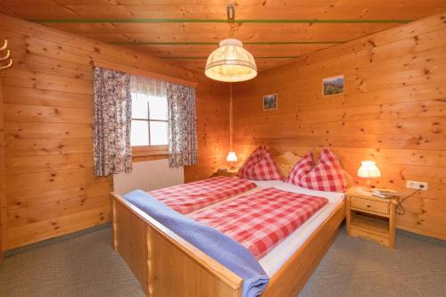 ein Schlafzimmer mit einem Bett in einem Blockhaus in der Unterkunft Apartment Deml in Flachau