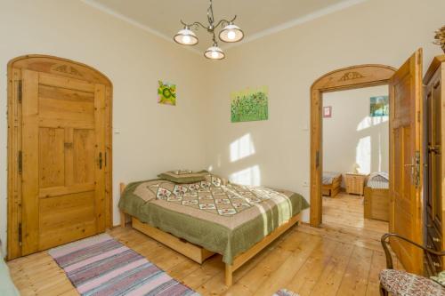 a bedroom with a bed and a wooden door at Vila Josefina Jizerské hory in Josefuv dul