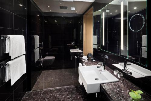 a bathroom with a sink and a toilet and a mirror at Melia Vienna in Vienna
