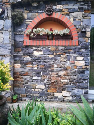 a stone wall with a window with a cross on it at B&B collina e mare in Camogli